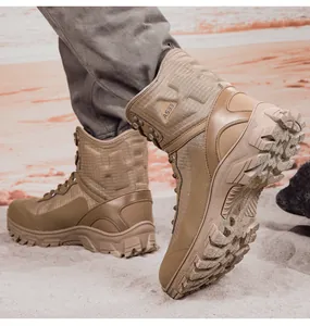 Detailed view of khaki mid-top tactical boots featuring a durable lugged outsole on sand