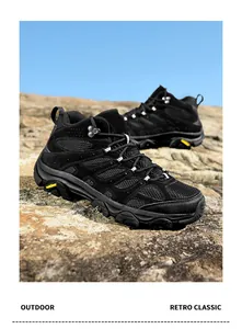 Close-up view of black breathable outdoor hiking shoes placed on a natural rocky terrain
