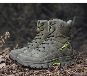 Side view of olive green high-top tactical boots in a rugged outdoor setting