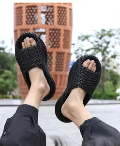 Gros plan de claquettes en maille imprimée 3D noires avec semelle épaisse ajourée
