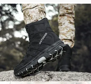 Side view of high-top black tactical outdoor boots with durable tread on rocky terrain