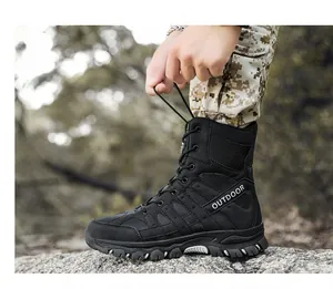 Close-up side view detail of black tactical combat boot in outdoor rugged terrain.