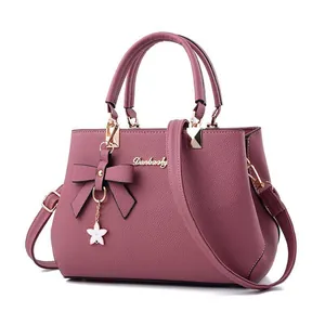 Elegante malvenfarbene Handtasche mit Schleife für Damen mit Umhängeriemen und Blumenanhänger