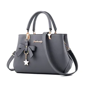 Elegante graue Handtasche aus genarbtem Leder mit Schleife und Sternanhänger