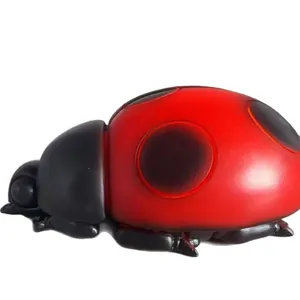 Vista dettagliata della luce notturna in resina a forma di coccinella rossa e nera.