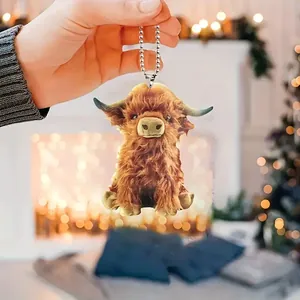 Detailed handheld view of cute highland cow hanging ornament for car mirror decoration