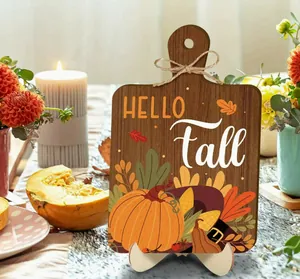 Close-up of a rustic wooden Hello Fall cutting board plaque in a harvest scene.