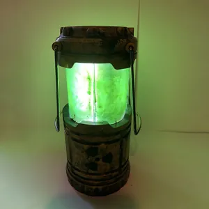 Lanterna reattore nucleare in miniatura con luce verde e un design rustico invecchiato