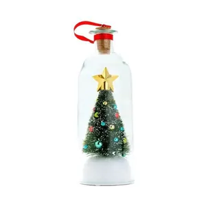 Detailopname van een glazen decoratiefles met een mini kerstboom en gouden ster op de top.