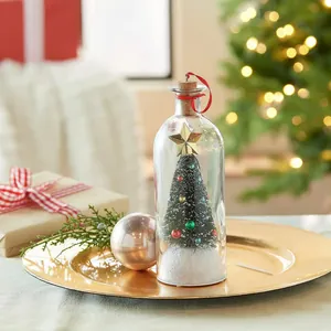 Detail van een miniatuur kerstboom in een decoratief glazen flesje voor kerstversiering