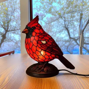 Zijaanzicht van een gloeiende rode kardinaal vogel tafellamp van hars op tafel
