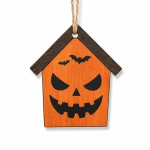 Close-up detail of Halloween wooden house ornament with pumpkin face and bat designs.