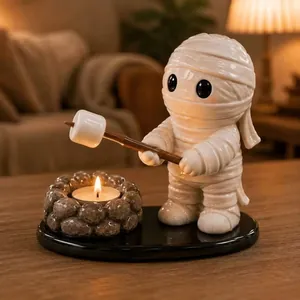 Detailed view of a mummy figurine roasting a marshmallow on a cozy campfire tealight holder