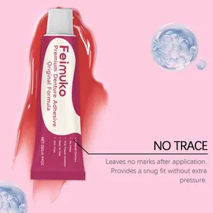 Detail view of Feimuko premium denture adhesive tube on a pink water-splash background