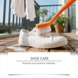 Détail d'une brosse orange nettoyant des baskets blanches pour la protection du tissu.