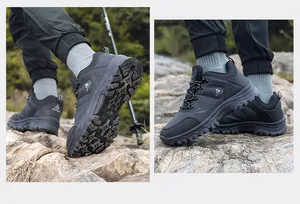 Close-up side view of men's black hiking shoes on rocky terrain with durable lug sole
