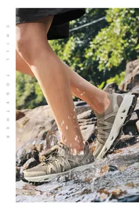 Detalle de los zapatos de montaña SkyPilot caminando por el agua corriente del río