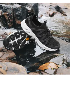 Detalle de zapatos SkyPilot que muestra malla transpirable y suela antideslizante en rocas