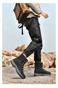 Detailed side view of black high-top tactical boots worn while walking on rocky terrain