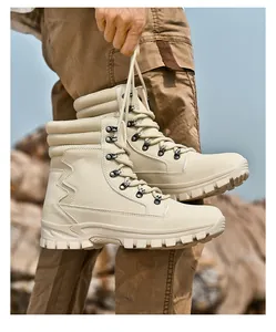 Detailed view of durable beige high-top tactical outdoor boots being held against nature
