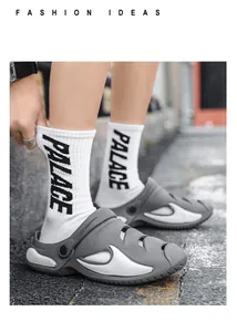 Stylish gray outdoor clogs with white wave pattern being worn in a street setting.