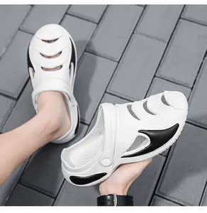 Close-up of white and black men's beach clogs showing side cut-outs and EVA texture.