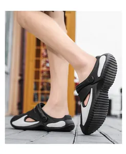 Detailed side view of black and white beach clog sandals worn for outdoor casual use
