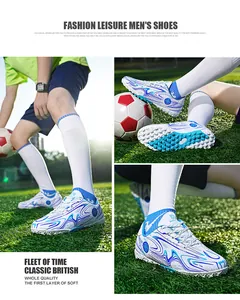 Detailed macro view of white and blue patterned soccer boots featuring turf studs on grass