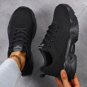 Close-up view of black breathable fly knit sneakers featuring a trendy chunky sole