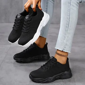 Detail view of black breathable knitted sneakers showing the fabric texture and chunky sole