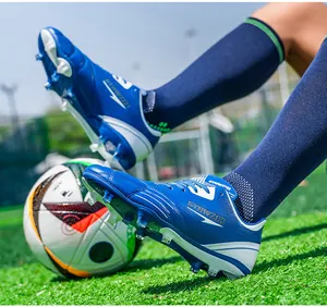 Detailed view of blue spikes on soccer shoes during game play on lush green grass