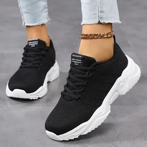 Detail view of stylish black breathable mesh sneakers with a chunky white sole.