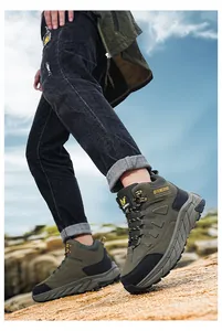 Action detail of men's high-top hiking boots on rocky terrain for outdoor camping