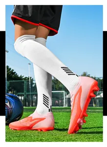 Close-up of pink fly woven soccer cleats on artificial turf field during action