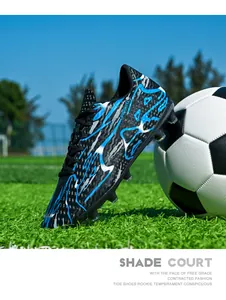 Detailed side profile of blue lightning soccer cleats on a green field with a ball