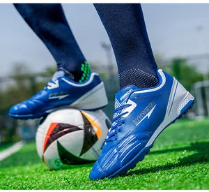 Action-packed close-up of blue breathable soccer shoes with cleats on a green grass turf