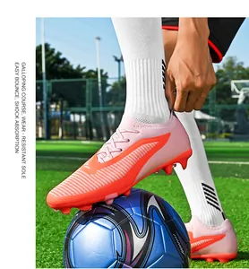 Detailed action shot of pink seamless fly-knit soccer cleat resting on a football.