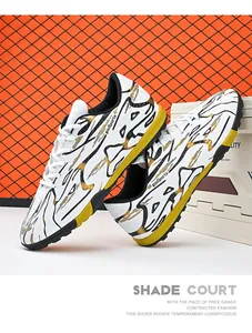 White and gold low-top soccer shoes with turf cleats for artificial grass training.