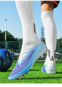 Detailed close-up of blue flying knit soccer cleats on artificial turf during training.
