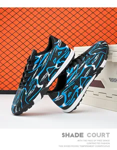 Close-up of low-top soccer shoes featuring vibrant blue lightning patterns and turf studs.