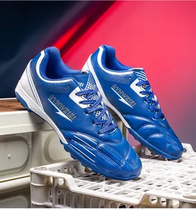 Detailed side view of blue and white soccer cleats with synthetic upper and TF sole