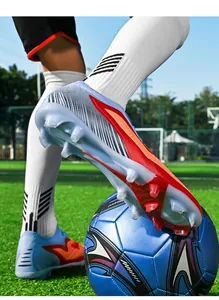Detail of durable studs on seamless fly-knit soccer shoes for artificial turf