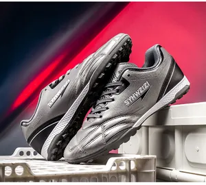 Detail view of metallic silver youth soccer turf shoes with SYHWZIZI branding logo