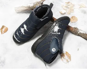 Durable dark blue winter snow boots with warm plush lining shown on a snowy background