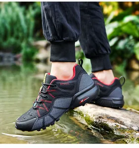 Detailed view of men's breathable black and red outdoor hiking shoes in a water setting