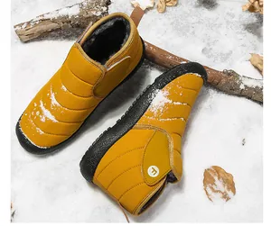 Macro detail of yellow quilted winter snow boots with warm fleece lining on snow