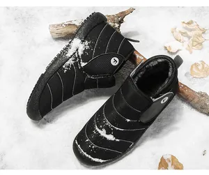 Close-up of black winter snow boots with fleece lining on snow background