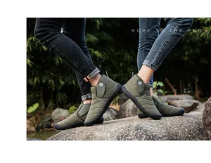 Detail of waterproof green snow boots for winter outdoor activities on rocky terrain
