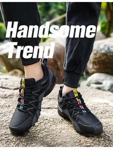 Close-up of durable black men's outdoor hiking shoes on a rocky path outdoors.