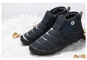 Warm navy blue winter snow boots with soft fleece lining presented on snowy background